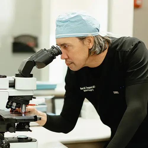 Mohs surgeon examining tissue under a microscope