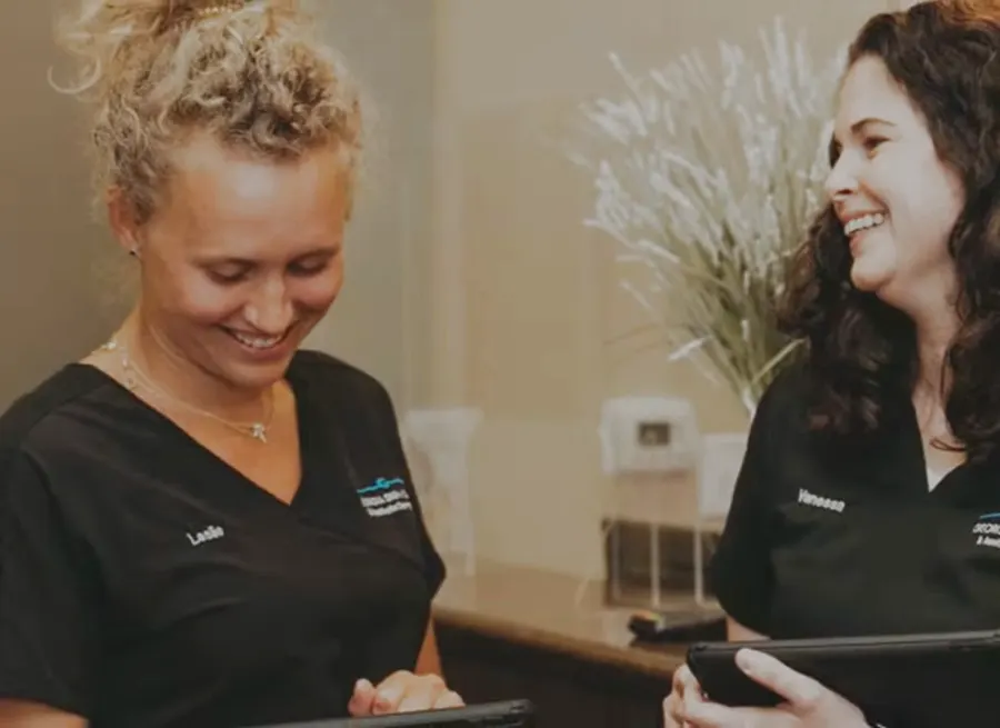Two Georgia Derm team members reviewing patient information on tablets